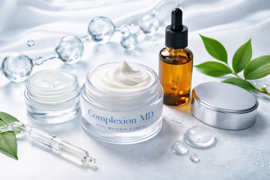 Anti-aging skincare products including a peptide cream jar, hyaluronic acid serum dropper bottle, and hydrating gel placed on a soft light background with water droplets and green leaves.